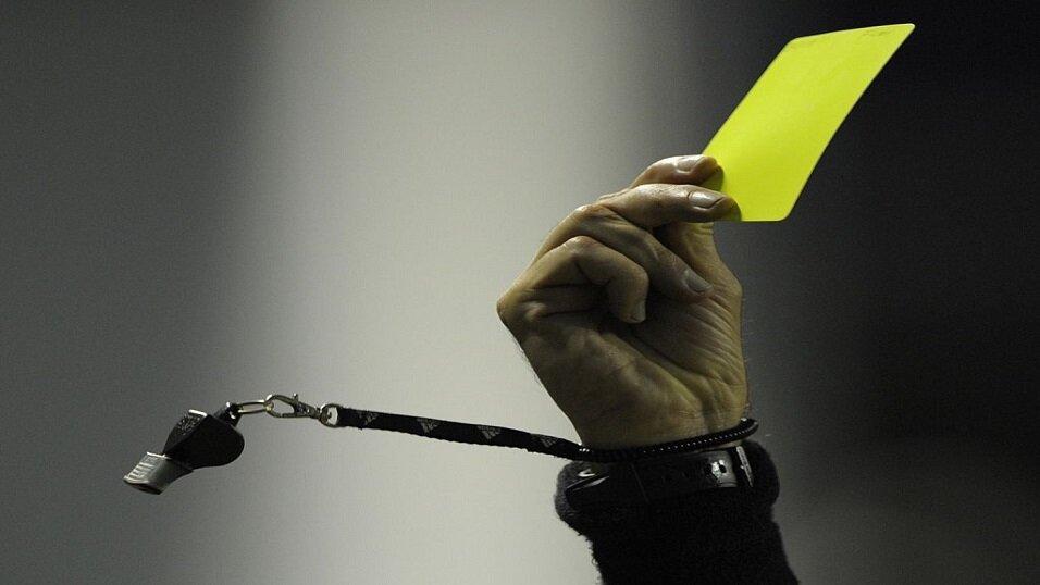 Referee gives player yellow card